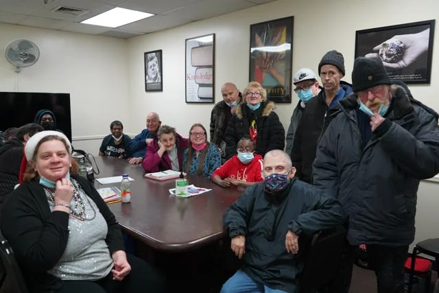 CVR behavioral health program participants and staff gathered around a table in a meeting room.